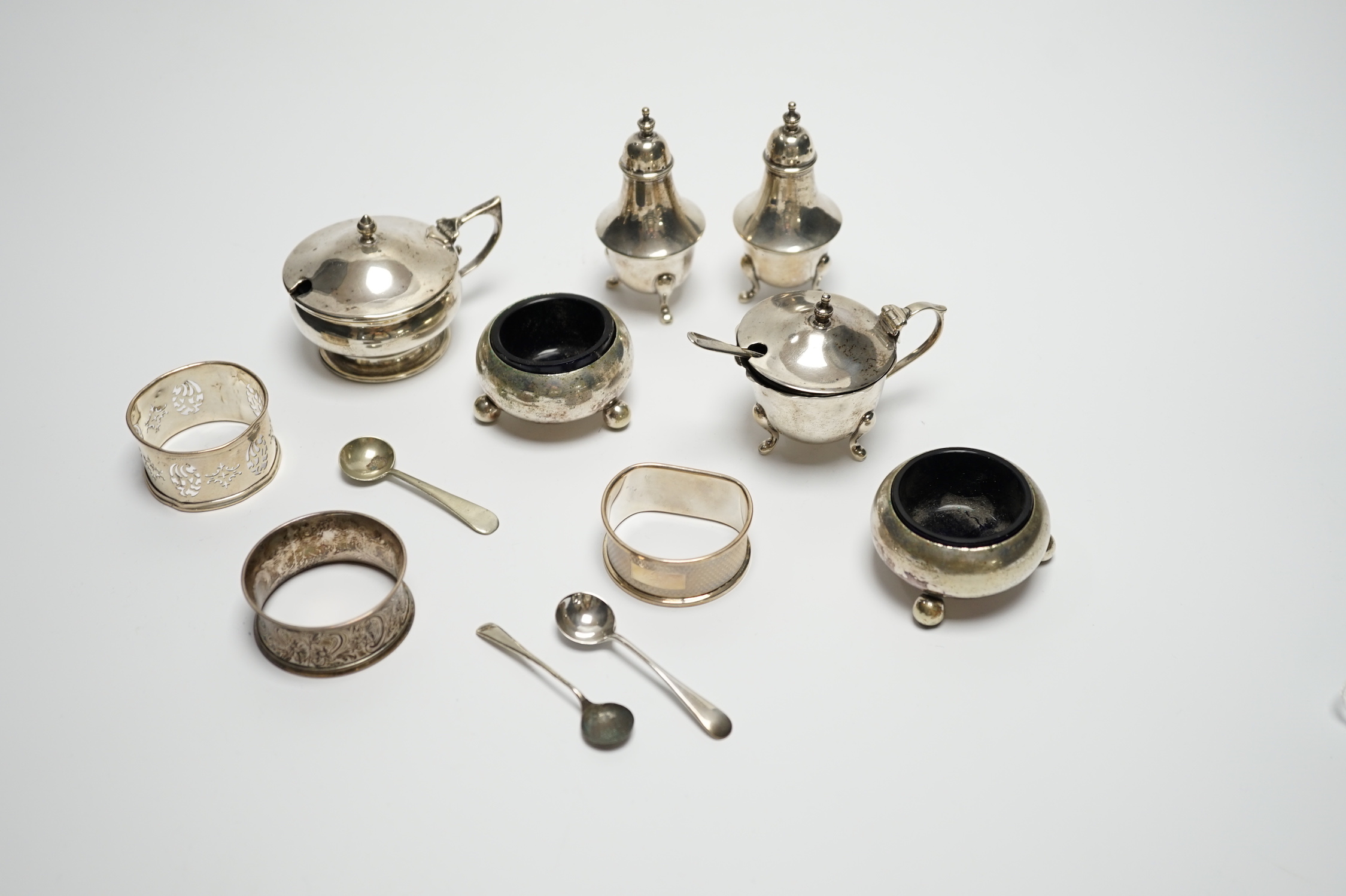 Six assorted silver cruets and three silver napkin rings.